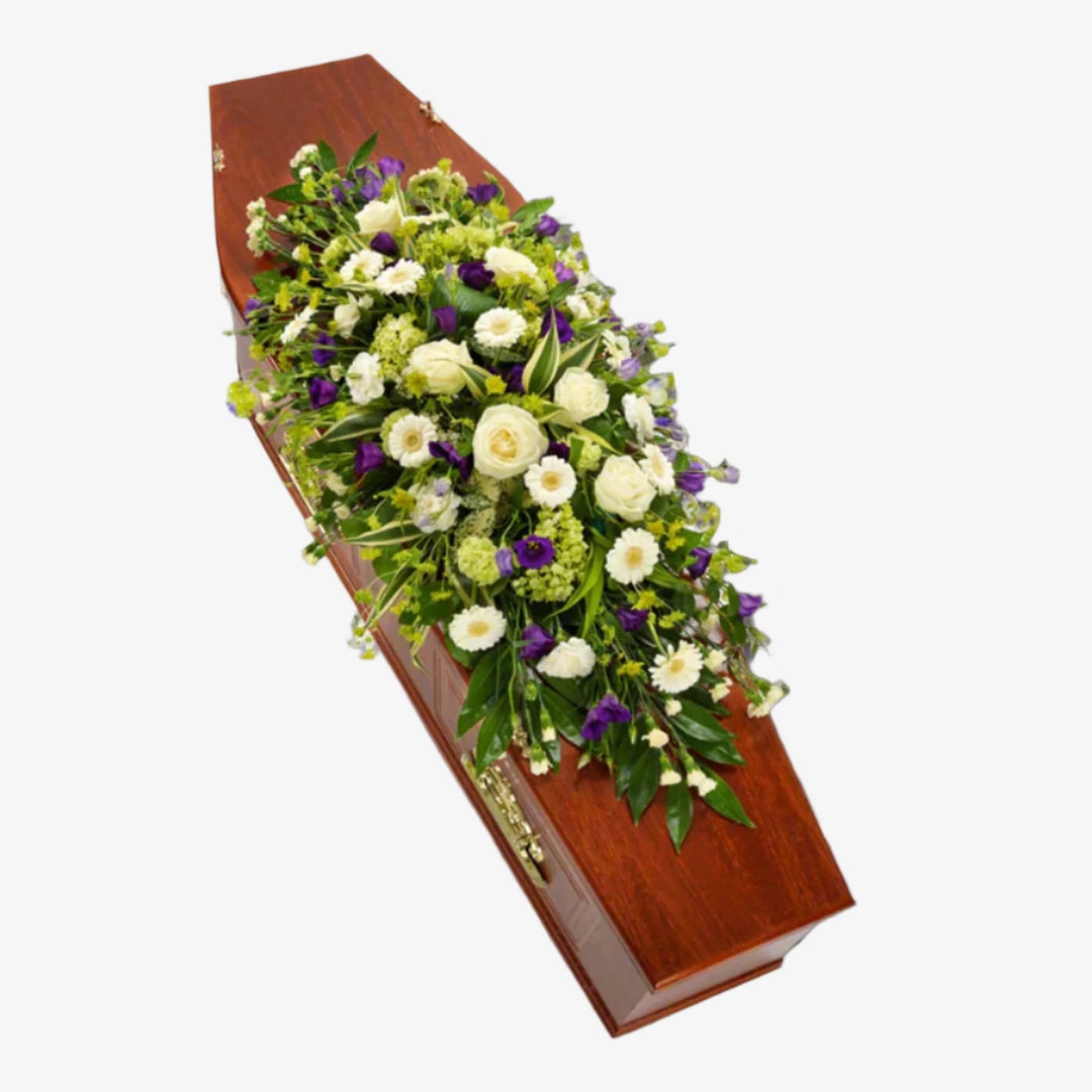 White & Purple Casket Spray - Magnolia the Florist A gorgeous white casket spray interspersed with purple Lisianthus blooms. White Roses, Germini, Carnations and Viburnum are lovingly arranged with an assortment of foliage. If you cannot find what you want on our site, please call our sales team, we're always happy to assist you This item requires 2 days notice to order. (Please note this item is only available in our local delivery area. See our delivery page for more information).