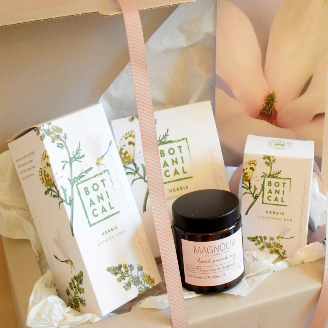 Herbis Botanical Bath Deluxe Gift Box - Magnolia the Florist Relax and unwind with the Flores Botanical Bath Gift Box! Featuring a combination of a scented candle, Flores bath salts, Flores cleansing bar, and Flores bathing foam, this luxurious set will help you take time to pamper your skin and soothe your senses. All presented in a stylish gift box and bow, this bath selection is the perfect addition to your bathroom. This item requires 1-day notice to order.