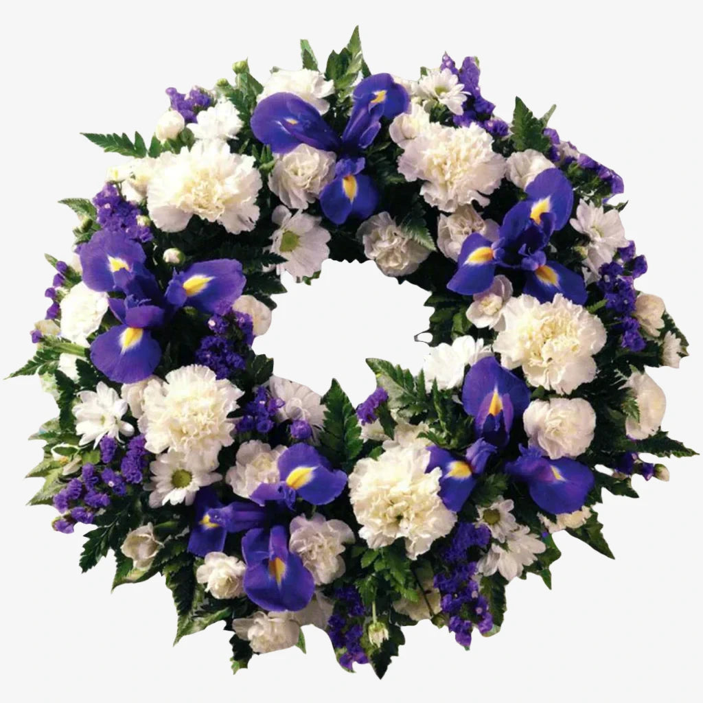 Purple & White Wreath - Magnolia the Florist A classic selection of flowers including Irises, Carnations and Spray Chrysanthemums in purple and whites are nestled into this traditional circular wreath. If you cannot find what you want on our site, please call our sales team, we're always happy to assist you This item requires 2 days notice to order.