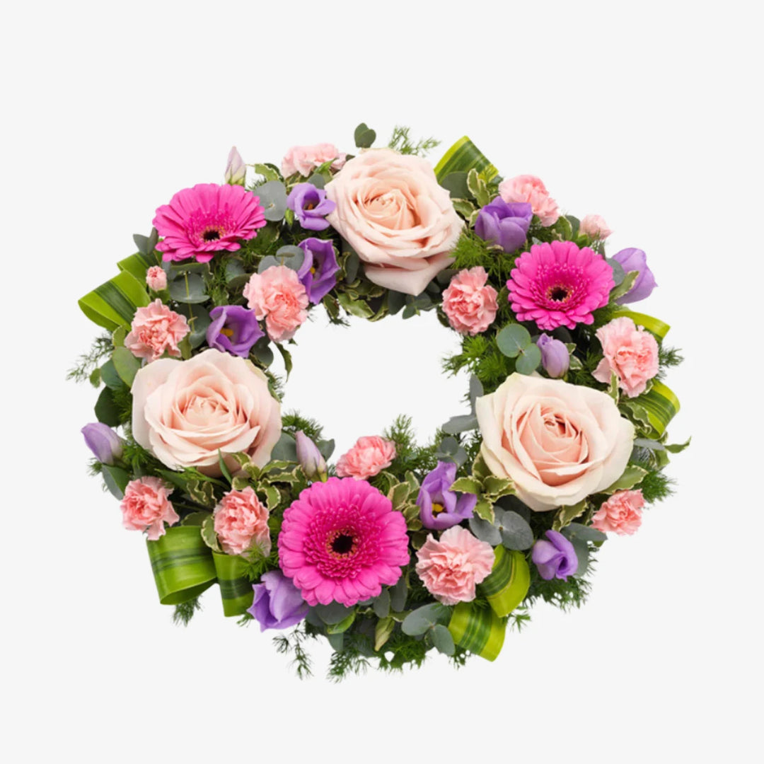 Pink Wreath - Magnolia the Florist A pretty pink wreath featuring Roses, Germini and Carnations with lilac Lisianthus and mix of luscious green foliage. If you cannot find what you want on our site, please call our sales team, we're always happy to assist you This item requires 2 days notice to order.