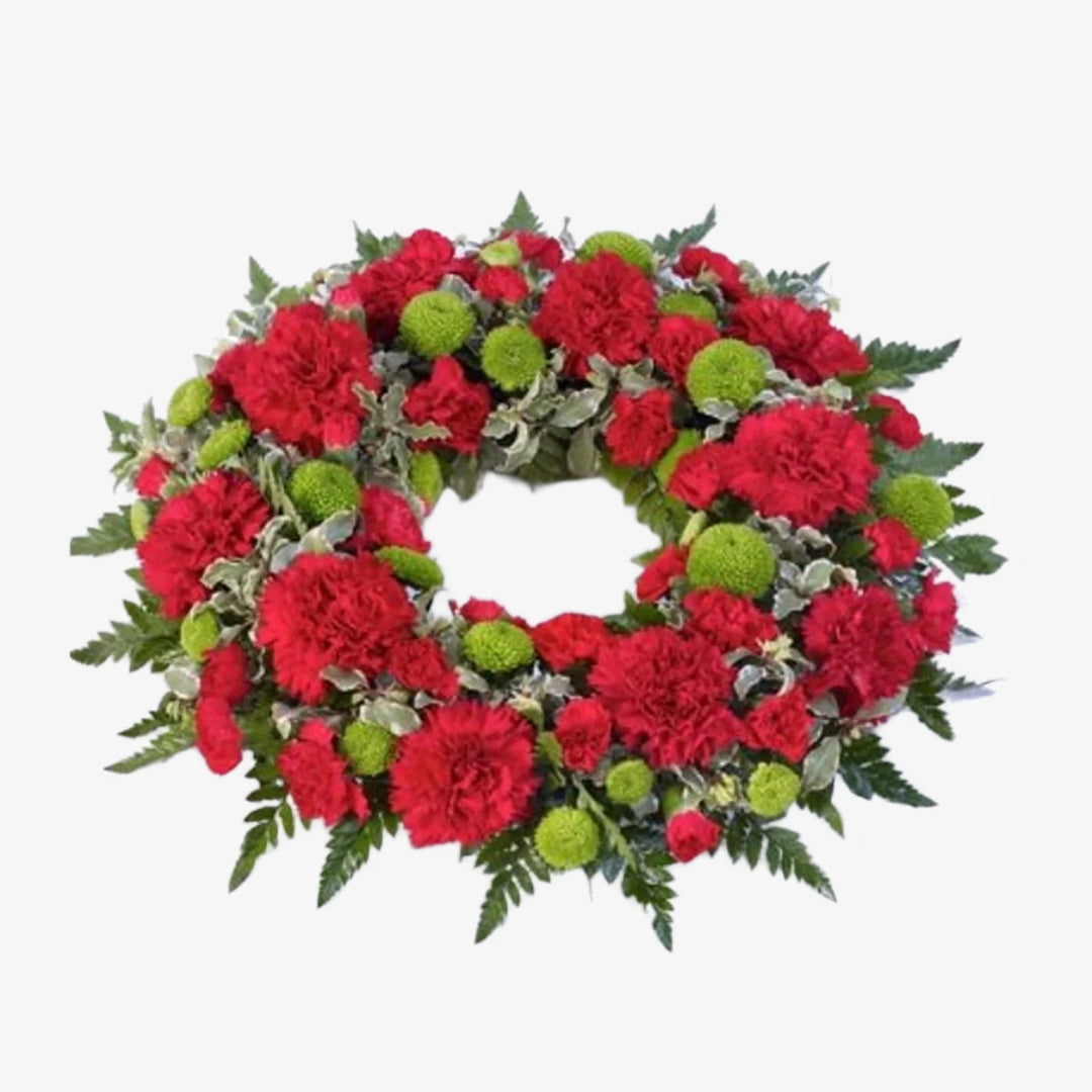 Carnation Wreath - Magnolia the Florist This elegant funeral wreath blends bloom and spray carnations, accented by green button chrysanthemums and foliage. The image depicts the beautiful contrast of red carnations against a bed of greenery and we can change the carnation colour if required, please select from below. If you cannot find what you want on our site, please call our sales team, we're always happy to assist you. This item requires 2 days notice to order.